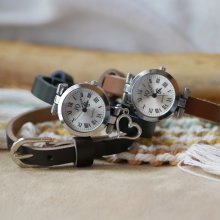 Silverfärgad klocka med läderarmband och silverfärgat spänne